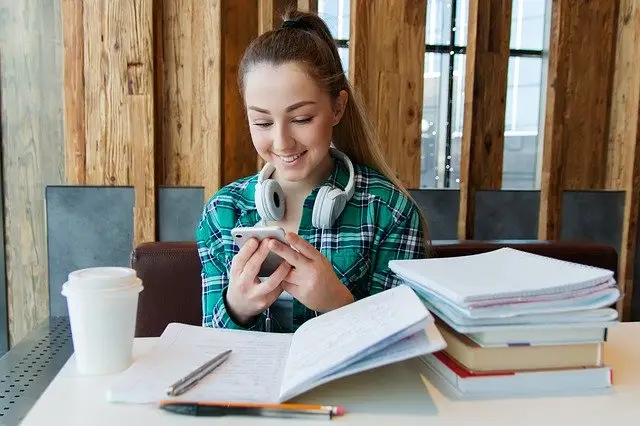 cuerpo_niña_estudiando_libros_teléfono